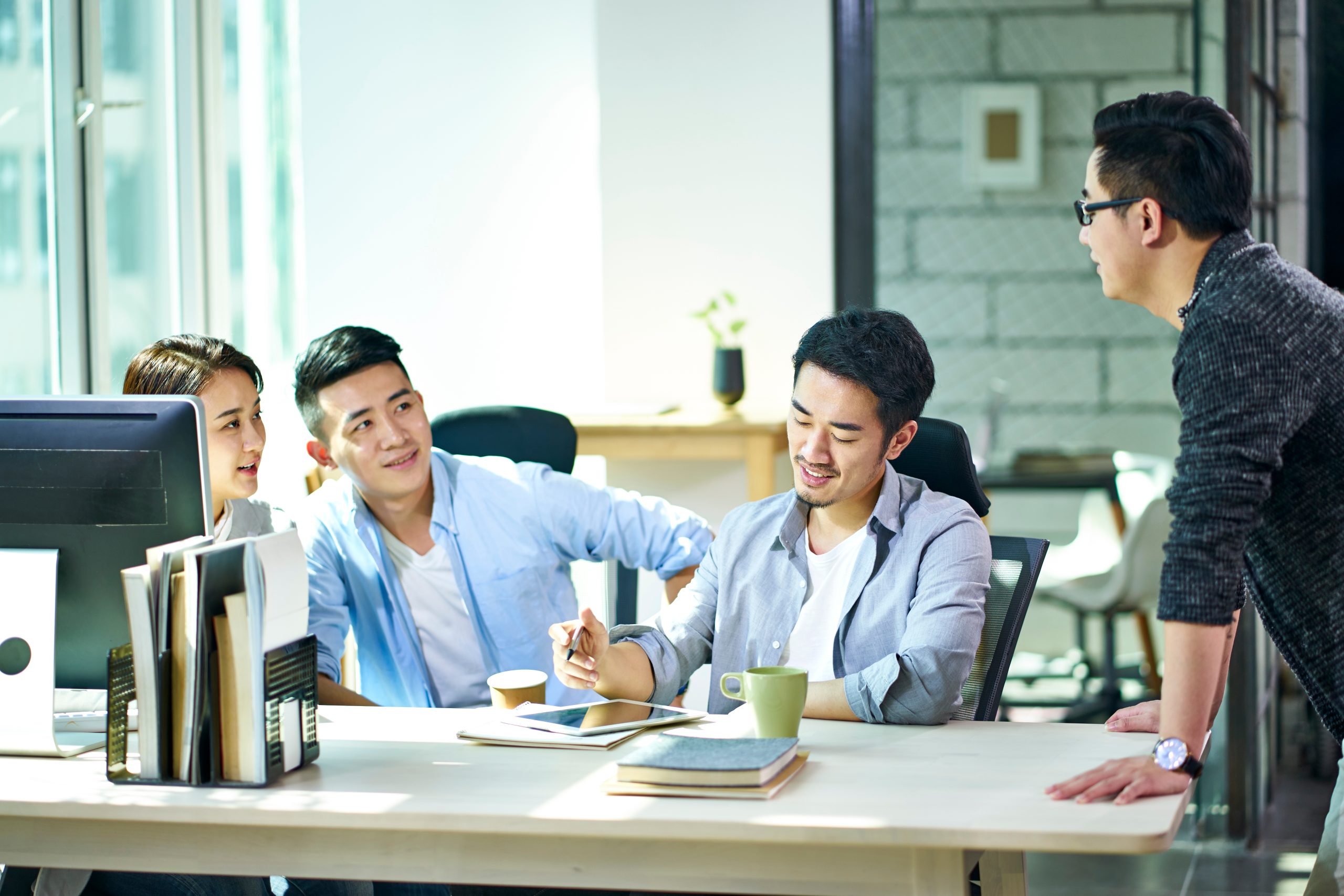four young asian entrepreneurs meeting in office four young asian entrepreneurs meeting in office