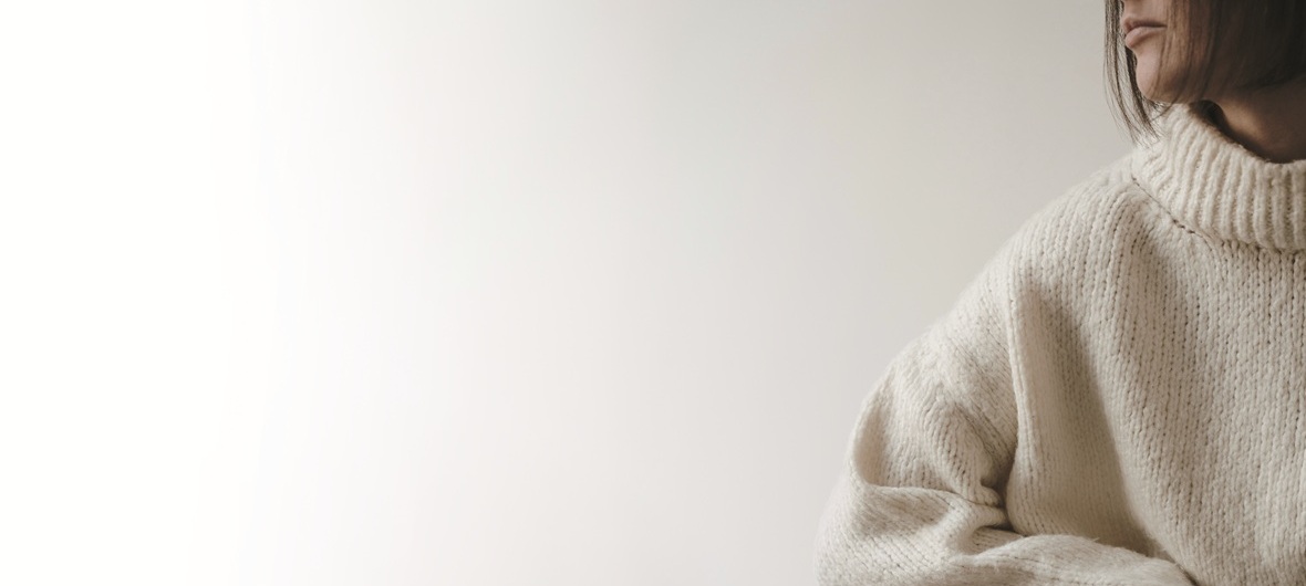 Closeup view of young pretty woman in beige sweater. Aesthetic f